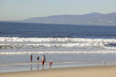 Foto de Padre con niños camina en la playa del mar - Imagen libre de derechos