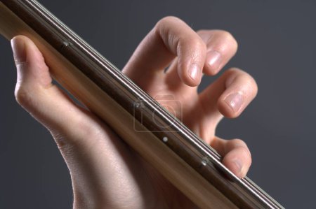 Foto de Hombre tocando en el bajo guitarra en el fondo, de cerca - Imagen libre de derechos