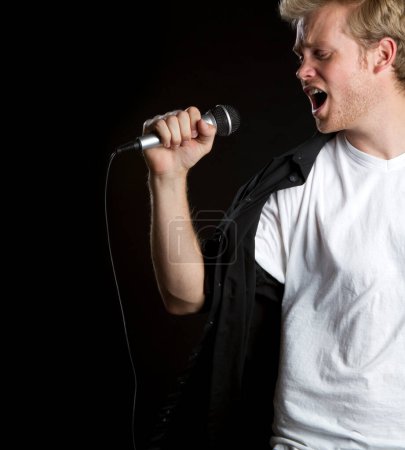 Téléchargez les photos : Singing Man sur fond noir - en image libre de droit