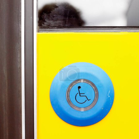 Téléchargez les photos : Mur jaune avec bouton bleu fauteuil roulant - en image libre de droit