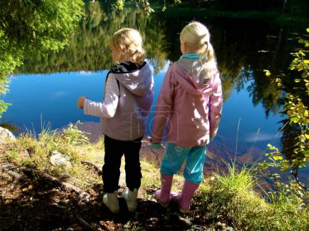Téléchargez les photos : Style de vie scandinave - les filles jouent dans la nature près de la rivière - en image libre de droit