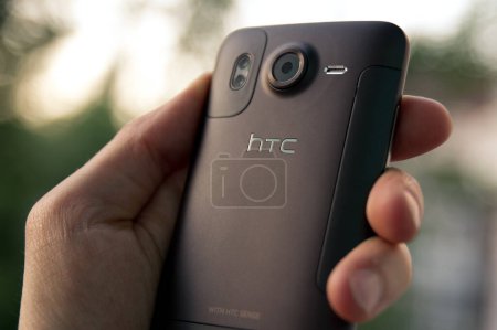 Téléchargez les photos : Maintenez la main HTC Desire HD smartphone - en image libre de droit