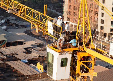 Photo for Men repair crane on high rise block - Royalty Free Image