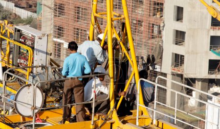 Téléchargez les photos : Gros plan hommes réparation entretien grue à grande hauteur - en image libre de droit
