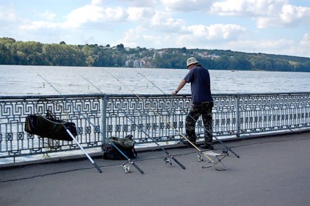 Téléchargez les photos : Man with fishing rod at the pier - en image libre de droit
