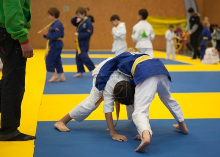 Téléchargez les photos : Les enfants aux prises pendant le combat des arts martiaux - en image libre de droit