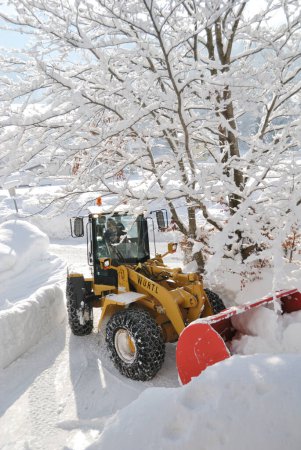 Téléchargez les photos : Travailleur nettoie une neige couverte dans la neige. - en image libre de droit