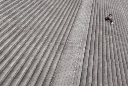 Téléchargez les photos : Jeune homme assis sur le toit d'un bâtiment - en image libre de droit