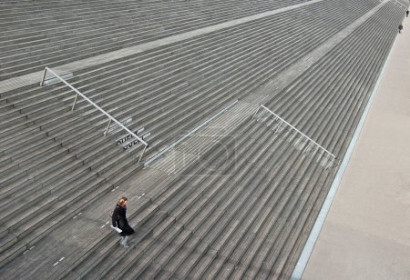 Téléchargez les photos : Jeune femme en manteau marchant dans les escaliers - en image libre de droit