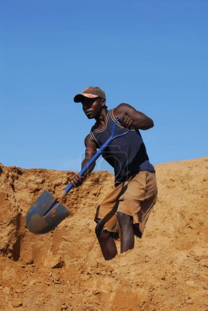 Photo for African worker with shovel working in the sand. - Royalty Free Image