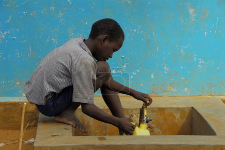 Téléchargez les photos : Enfant africain avec robinet d'eau - en image libre de droit
