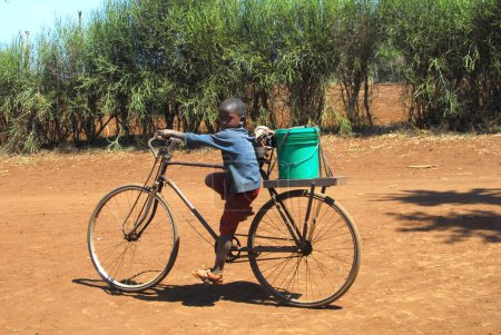 Foto de African child on bicycle looking at camera - Imagen libre de derechos
