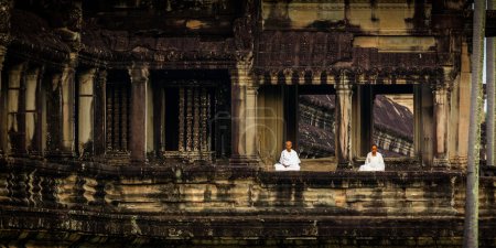 Foto de Las monjas meditan en la ruina de Angkor Wat al amanecer - Imagen libre de derechos