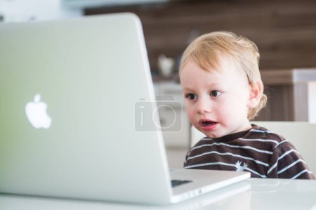 Téléchargez les photos : Petit garçon avec ordinateur portable, La génération de pomme - en image libre de droit