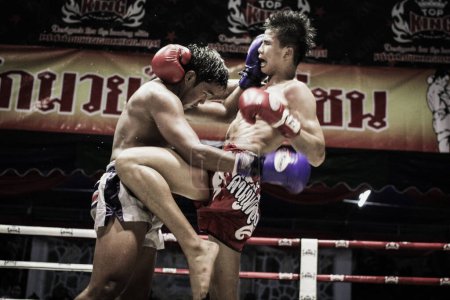 Téléchargez les photos : Deux hommes musclés torse nu combattant Kick boxing combat dans le ring de boxe - en image libre de droit