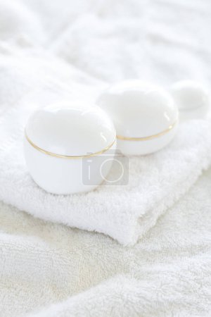 Photo for Cosmetic containers lying on white towel - Royalty Free Image