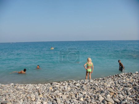 Photo for People resting and swimming on sea beach - Royalty Free Image