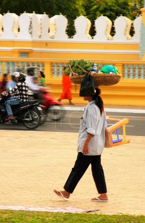 Photo for Cambodian woman carrying basket on her head - Royalty Free Image