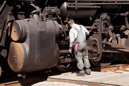 Photo for Mechanic checks locomotive outdoor - Royalty Free Image