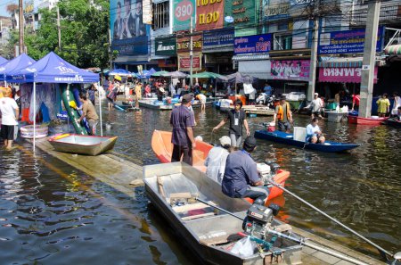 Téléchargez les photos : Transport de personnes dans les rues inondées - en image libre de droit