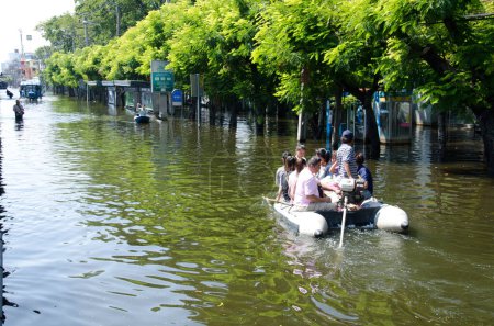 Téléchargez les photos : Transport de personnes dans les rues après les inondations - en image libre de droit