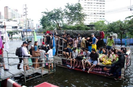 Téléchargez les photos : Camion transporte un groupe de personnes pour évacuer de la zone inondée - en image libre de droit