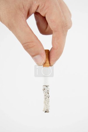 Téléchargez les photos : Main tenant une cigarette sur fond blanc - en image libre de droit