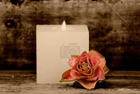 Foto de Vela ardiente con rosa sobre fondo de madera - Imagen libre de derechos