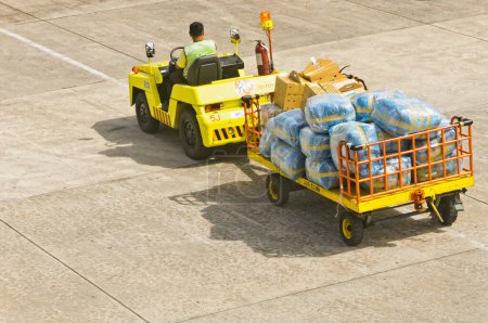 Téléchargez les photos : Chariot élévateur avec bagages sur la route à ariport - en image libre de droit