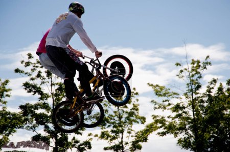 Photo for Bmx riders performing tricks on bicycles at the park. - Royalty Free Image
