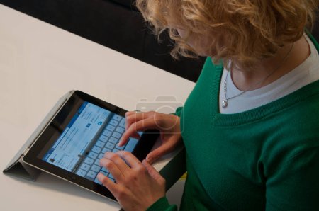 Téléchargez les photos : Femme utilisant Apple iPad sur le site Facebook - en image libre de droit