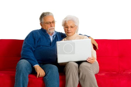 Téléchargez les photos : "Couple âgé sur le canapé à l'aide d'un ordinateur portable
" - en image libre de droit