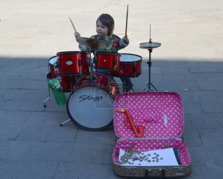 Photo for Young kid child play with drums street music day - Royalty Free Image