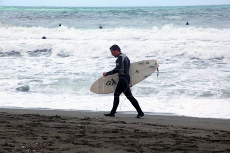 Téléchargez les photos : Surfeur sur la plage de Levanto, ouverture de la saison de spectacles - en image libre de droit