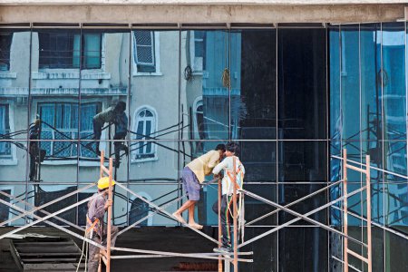 Photo for Reflections of the scaffolding and workers - Royalty Free Image