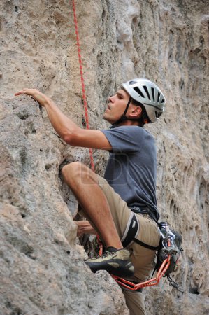 Téléchargez les photos : Homme grimpeur accroché à une falaise - en image libre de droit