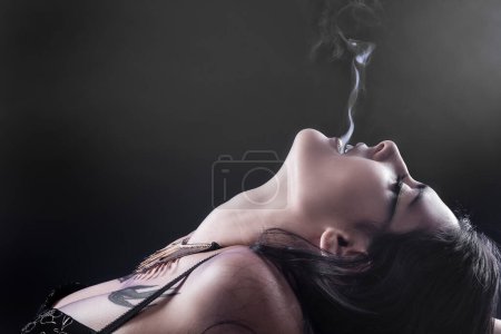 Téléchargez les photos : Fumer, femme tatouée avec une flamme de fumée - en image libre de droit