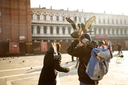 Téléchargez les photos : Personnes heureuses avec colombes appréciant le paysage dans la ville de Venise, Italie - en image libre de droit