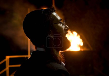 Téléchargez les photos : MERON, ISRAEL - 10 MAI : Homme juif non identifié près d'un feu de joie lors du Lag Ba'omer dans le tombeau de Bar Yochai à Meron, Israël, le 10 mai 2012, Lag Ba'omer est une fête juive dans laquelle il est d'usage d'allumer un feu de joie - en image libre de droit