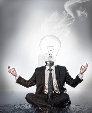 Téléchargez les photos : "Homme d'affaires avec tête d'ampoule assis en position de méditation
" - en image libre de droit