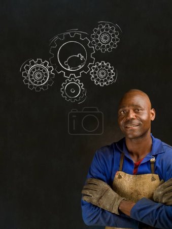 Foto de Africano negro hombre industrial trabajador con tiza hámster engranajes pizarra - Imagen libre de derechos