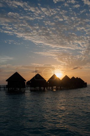 Foto de La salida del sol sobre bungalows de agua en increíbles villas de agua - Imagen libre de derechos