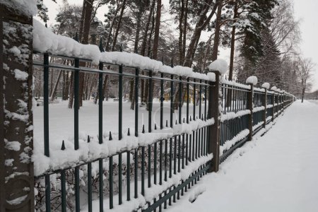 Téléchargez les photos : Clôture avec neige dans le parc - en image libre de droit