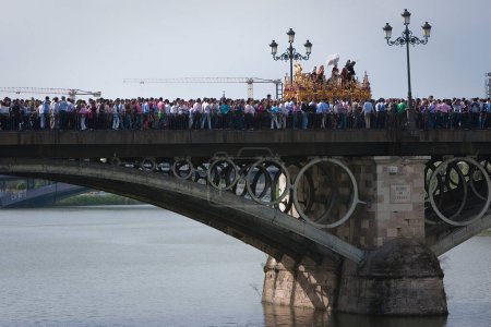 Photo for Brotherhood of San Gonzalo passing the holy Monday by the Puente de Triana, Seville, Spain - Royalty Free Image
