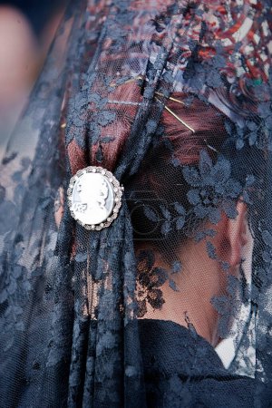 Photo for Detail of mantilla and touched embroidered black with silver snap during a procession of holy week, Andalusia, Spain - Royalty Free Image