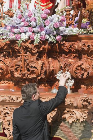 Foto de Capataz tocando con la persona que llama de plata para conseguir el trono durante una procesión de Pascua, Andalucía, España - Imagen libre de derechos