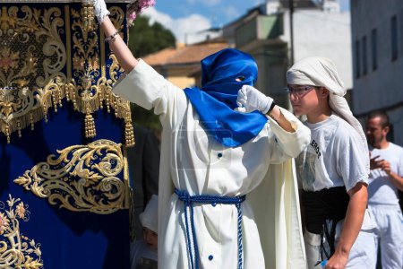 Foto de Nazareno que va con la mano en la manigueta el trono en una procesión de Semana Santa, España - Imagen libre de derechos