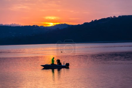 Téléchargez les photos : Pêcheurs sur le bateau au coucher du soleil - en image libre de droit