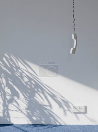 Photo for View of a telephone receiver hanging against wall in empty room - Royalty Free Image