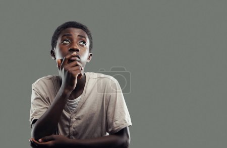 Téléchargez les photos : Garçon africain réfléchi avec la main sur le menton - en image libre de droit